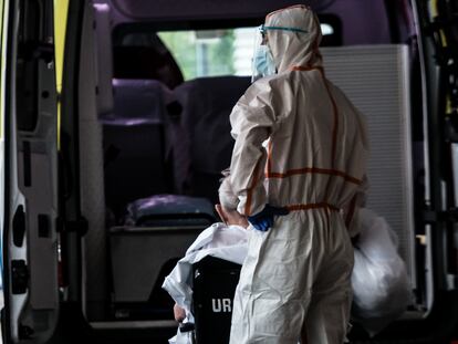 Un trabajador sanitario ayuda a un paciente en una ambulancia estacionada en la entrada de Urgencias del Hospital Universitario Doctor Josep Trueta (Girona).
