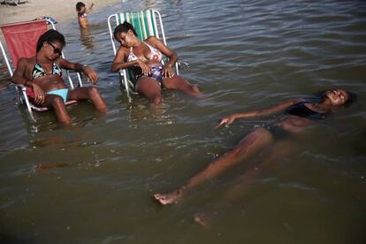 Tres mujeres se relajan en un estanque artificial conocido como piscinao, al norte de Río de Janeiro (Brasil).