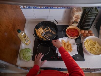 Una mujer fríe patatas este miércoles en su casa de Sevilla.