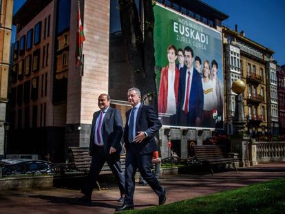 El lehendakari Urkullu, y el presidente del PNV, Andoni Ortuzar, caminan por delante del cartel electoral de su formación.