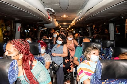 Pasajeros del Bus Playero Viajero con destino Benidorm durante la recogida de pasajeros en Madrid, la madrugada del sábado.