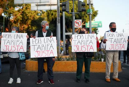 Conductores de autobuses y familiares, levantan carteles para exigir una aumento a las tarifas del transporte público, durante uno de los bloqueos en Ciudad de México, el 2 de junio de 2022.
