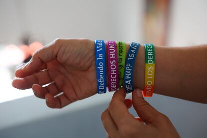 Lina Tabares, lideresa defensora de derechos humanos, muestra sus pulseras con las consignas que defiende.