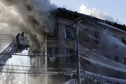 Carámbanos cuelgan del tendido eléctrico mientras los bomberos trabajan para contener un incendio en el Bronx, Nueva York (EE UU). 
