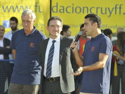 Xavi Hernández, a la derecha, y Cruyff, a la derecha, junto al embajador de la Obra Social La Caixa. 