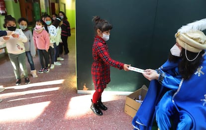 Una niña entrega su carta al paje de los Reyes Magos el último día de clase en en el colegio El Valles de Terrasa.