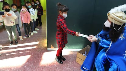 Una niña entrega su carta al paje de los Reyes Magos el último día de clase en en el colegio El Valles de Terrasa.