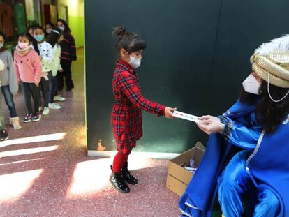 Una niña entrega su carta al paje de los Reyes Magos el último día de clase en en el colegio El Valles de Terrasa.