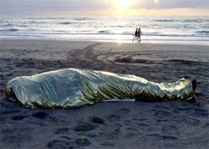 El cadáver del segundo inmigrante fallecido tras volcar ayer una patera en Fuerteventura yace cubierto en la playa de Solana Matorral, en la localidad de Morrojable.