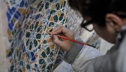 Un especialista trabaja en la recuperaci&oacute;n de un fragmento de trencad&iacute;s en el Park G&uuml;ell.