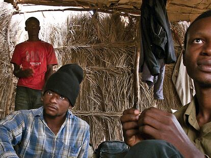 Thomas, de 20 años; Bright, de 21, y Kinsley, de 19 (de izquierda a derecha). Nigerianos. Han pagado 75.000 CFA (unos 115 euros) por el viaje a Libia. Llevan ya tres semanas esperando en Dirkou a que llegue el conductor.