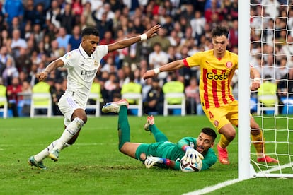 Rodrygo intenta rematar el balón ante Gazzaniga durante el partido entre el Real Madrid y el Girona, este domingo en el Bernabéu.