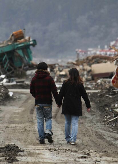 Una pareja camina entre el área devastada de Rikuzentakata, en el norte de Japón.