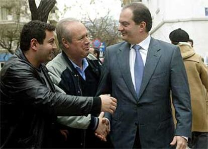 Costas Karamanlís recibe la felicitación de dos ciudadanos por su victoria electoral, ayer en Atenas.