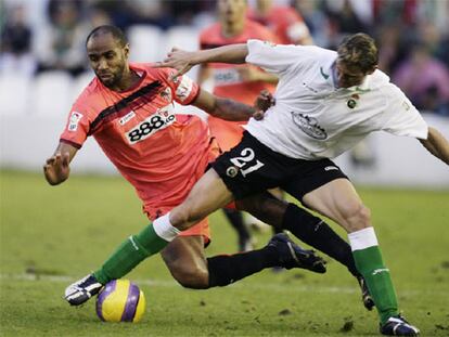 El sevillista Kanoute lucha un balón con e Ruben Gonzalez Rocha.