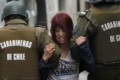 Una joven es detenida por la policía durante los disturbios registrados el jueves en Santiago.