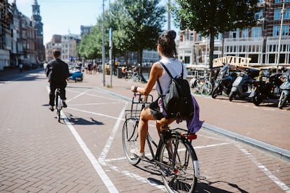 Varios ciclistas pedalean por una calle de Ámsterdam.