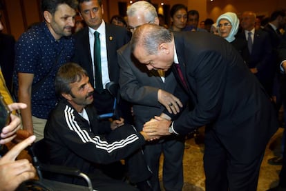 Erdogan da la mano a uno de los heridos en la asonada, durante una ceremonia en honor a los civiles muertos y lesionados en el fallido golpe de Estado, este viernes.