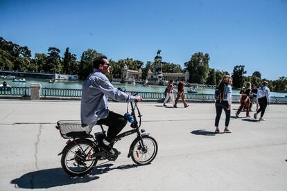 Varias personas pasean por el Parque del Retiro de Madrid.