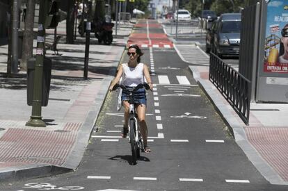Una mujer circula con su bicicleta por el carril bici de la calle de Santa Engracia.