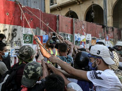 10 August 2020, Lebanon, Beirut: Anti-government activists try to put down the concrete block which is closing the road that leads to the house of the parliament during clashes with riot police in Beirut's downtown. The Lebanese government resigned following the massive Beirut port explosion of 04 August which killed at least 158 people, wounded 6000 and displaced some 250,000 to 300,000. Photo: Marwan Naamani/dpa
10/08/2020 ONLY FOR USE IN SPAIN