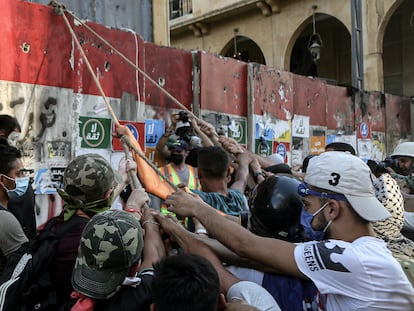 10 August 2020, Lebanon, Beirut: Anti-government activists try to put down the concrete block which is closing the road that leads to the house of the parliament during clashes with riot police in Beirut's downtown. The Lebanese government resigned following the massive Beirut port explosion of 04 August which killed at least 158 people, wounded 6000 and displaced some 250,000 to 300,000. Photo: Marwan Naamani/dpa
10/08/2020 ONLY FOR USE IN SPAIN