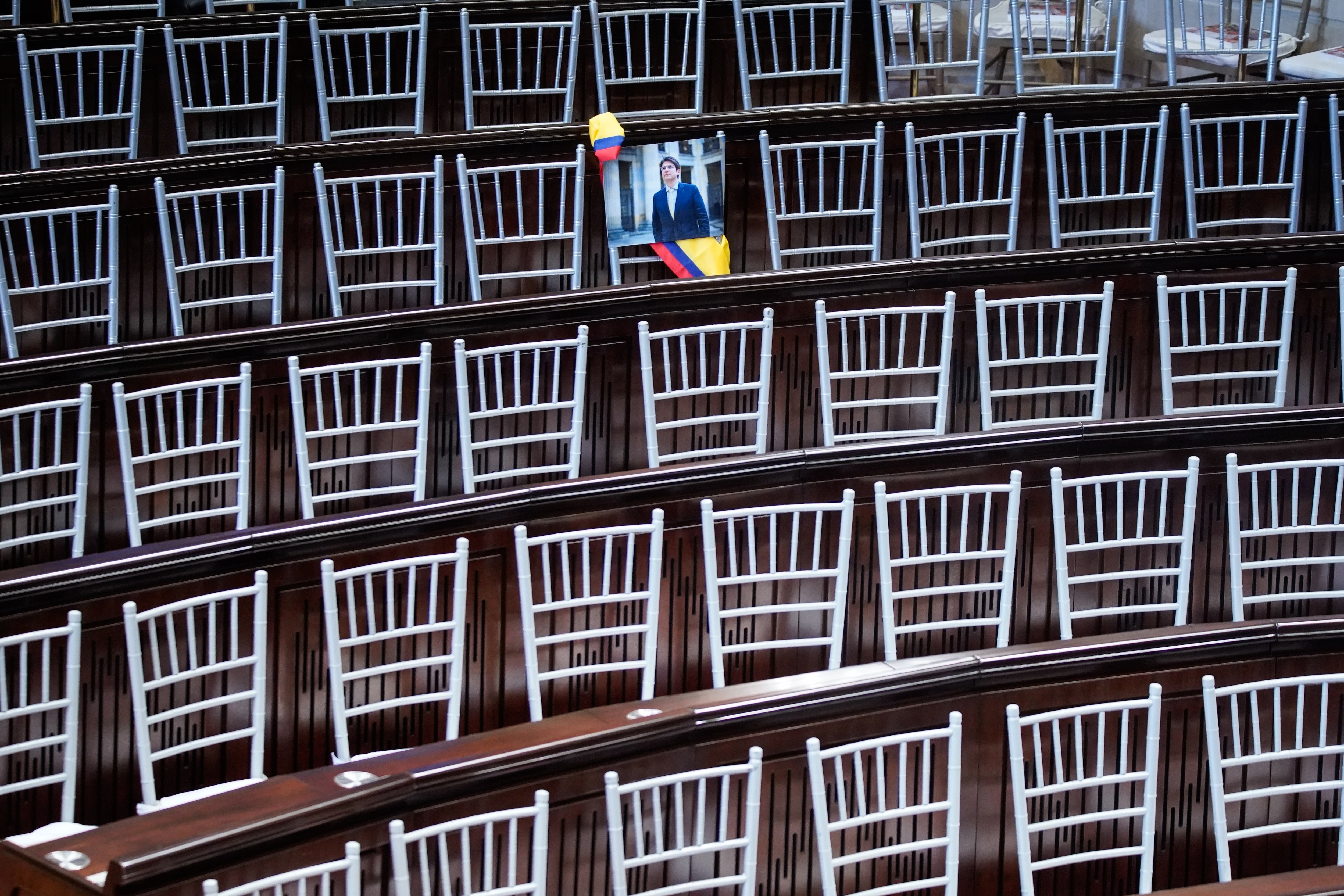 En apoyo al Senador Miguel Uribe miembros de su partido colocan una fotografía como acto de presencia del candidato en la Instalación  del Congreso.