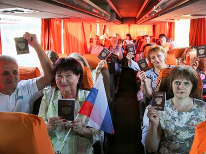 Habitantes de la región de Donetsk mostraban el pasado sábado sus pasaportes rusos en el autobús de camino a Rusia.