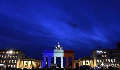 Un grup de manifestants davant la Porta de Brandenburg a Berlín (Alemanya), en la qual es reflecteixen els colors de la bandera francesa.