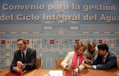 La presidenta de la Comunidad de Madrid, Esperanza Aguirre (2ºi), conversando con su vicepresidente, Ignacio González (1ºd), junto al alcalde madrileño, Alberto Ruiz-Gallardón (1ºi), durante el acto de la firma del convenio que cede el control de la depuración del agua de la capital durante 25 años a la CAM, a cambio de 700 millones de euros de aquí a 2008, acuerdo por el que el Canal de Isabel II asume el ciclo íntegro del agua en toda la región.