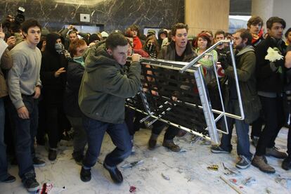 Un manifestantes arremete con mobiliario contra las vitrinas de la torro Milbank, donde está la sede del Partido Conservador británico.