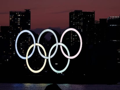 Unos aros olímpicos gigantes iluminados en Tokio.