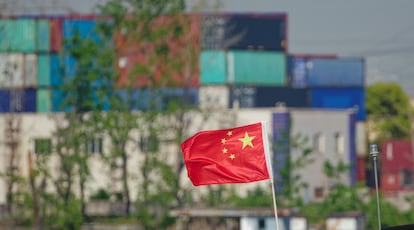 Una bandera china ondea en la terminal comercial del puerto de Shanghái.