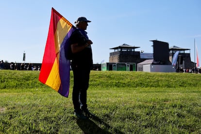 Un hombre sostiene una bandera de la Segunda República Española en el antiguo campo de concentración Mauthausen.