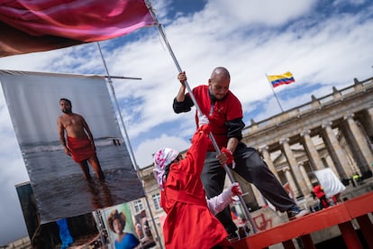 Dos activistas trans instalan banderas del proyecto en la Plaza de Bolívar, en Bogotá.