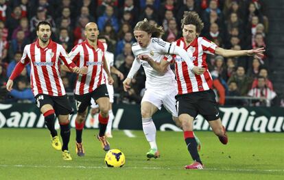 Modric lucha por el balón con Iturraspe.