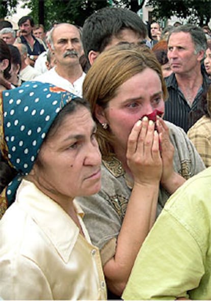 Familiares de los rehenes aguardan noticias junto a la escuela.