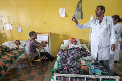 Doctor Darilow (Hospital de Wukro, marzo de 2015). El doctor Darilow, responsable de medicina interna del hospital de Wukro (localidad situada al norte de Mekele, la capital de Tigray) observa una radiografía ante la atenta mirada de un hombre y de la mujer que está postrada en la cama. En Wukro era frecuente ver a familiares compartiendo la cama del enfermo.