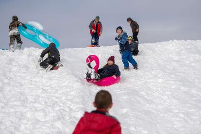 Un grupo de niños juegan en la nieve en Central Park, en Nueva York.