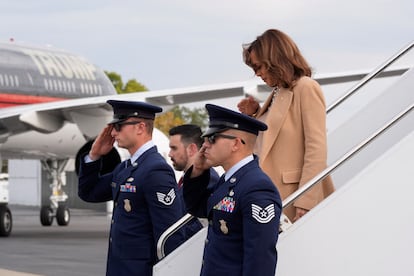 Kamala Harris steps off Air Force Two at Charlotte International Airport, North Carolina, with Donald Trump's campaign plane in the background.