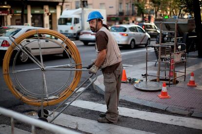 Un operario trabaja en el despliegue de fibra óptica en una calle de Madrid.