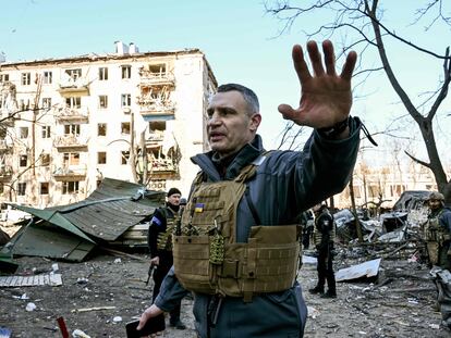 Kyiv's mayor Vitali Klitschko holds people away from a five-storey residential building that partially collapsed after a shelling in Kyiv on March 18, 2022, as Russian troops try to encircle the Ukrainian capital as part of their slow-moving offensive. - Authorities in Kyiv said one person was killed early today when a downed Russian rocket struck a residential building in the capital's northern suburbs. They said a school and playground were also hit. (Photo by Sergei SUPINSKY / AFP)