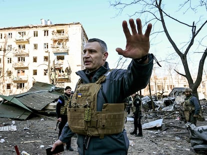 Kyiv's mayor Vitali Klitschko holds people away from a five-storey residential building that partially collapsed after a shelling in Kyiv on March 18, 2022, as Russian troops try to encircle the Ukrainian capital as part of their slow-moving offensive. - Authorities in Kyiv said one person was killed early today when a downed Russian rocket struck a residential building in the capital's northern suburbs. They said a school and playground were also hit. (Photo by Sergei SUPINSKY / AFP)