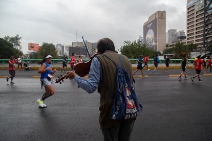 Un espectador toca el violín para animar a los corredores del XXXIX Maratón de la Ciudad de México.