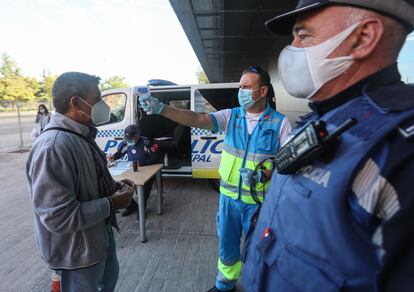 Personal sanitario toma la temperatura a un vecino de Vallecas, este martes. 