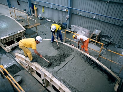 Un grupo de trabajadores allana un revestimiento de túnel de hormigón en España.