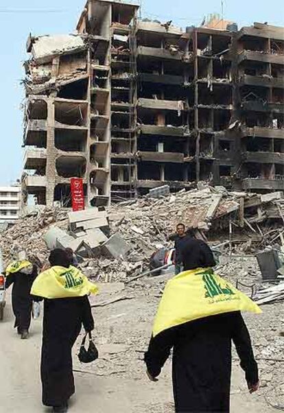Varias seguidoras de Hezbolá pasan ante un edificio derruido en Dahiyeh, en el sur de Beirut.