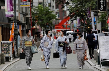 Mulheres passeiam em Tóquio com o traje tradicional de gueixa, em julho.