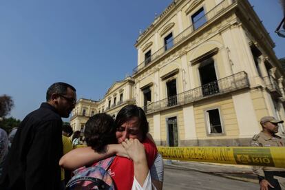 Funcionarios del Museo Nacional de Río de Janeiro lloran tras el incendio que se originó la tarde del domingo en la pinacoteca.