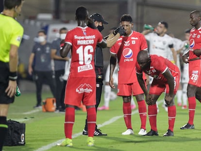 Un asistente ayuda a los jugadores del América de Cali afectados por los gases lacrimógenos durante su partido de Copa Libertadores contra Atlético Mineiro, en el estadio Romelio Martínez de Barranquilla.